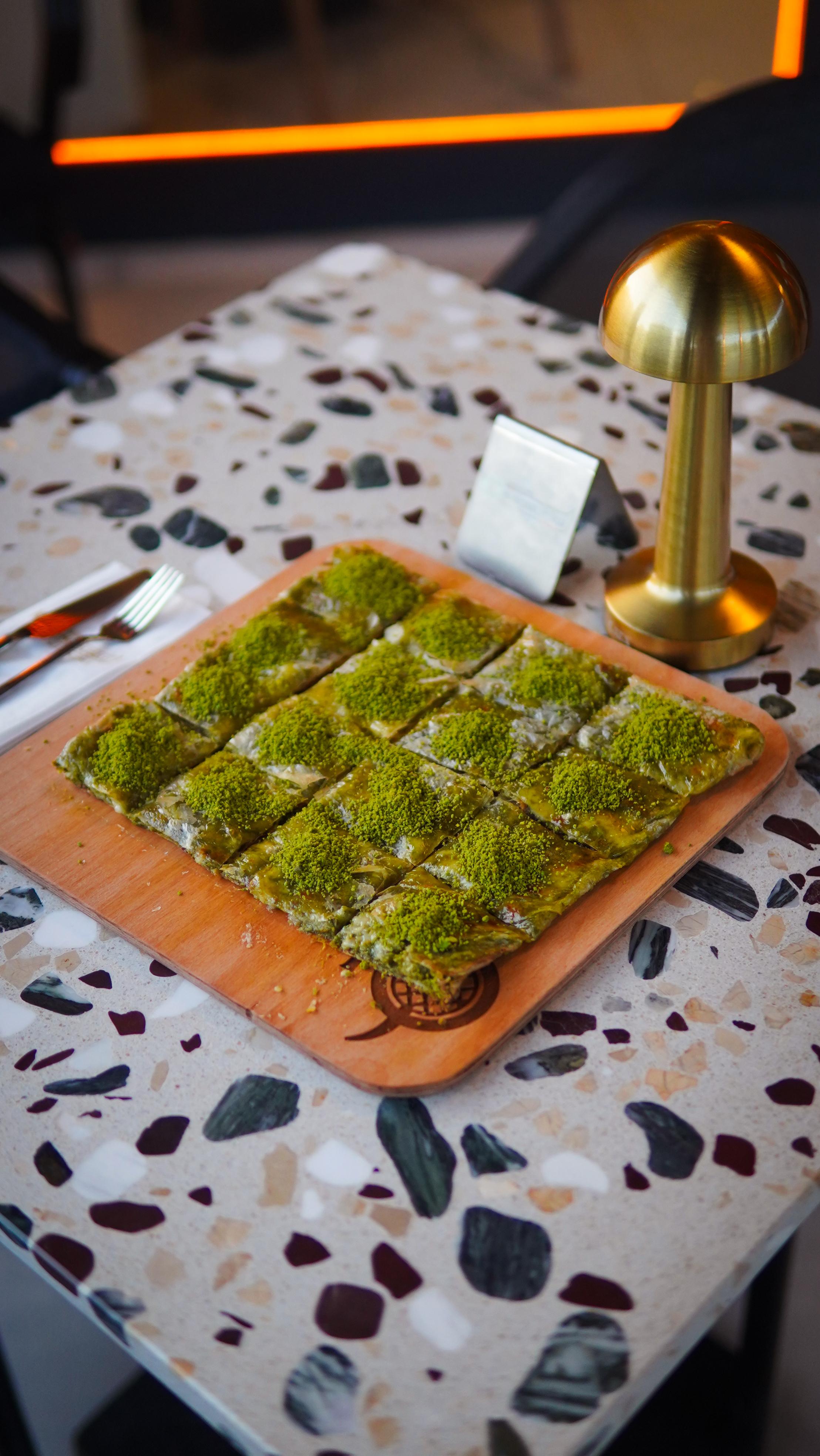 İnce açılmış katmer hamuru, kaymak ve fıstıkla